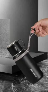 Vue détaillée de la bouteille isotherme noire en acier avec une sangle en silicone.
