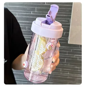 Close-up of portable purple straw water bottle with lemon slices and cute charms