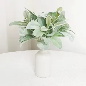 Close-up of soft flocked lamb's ear artificial leaves in a minimalist white ceramic vase