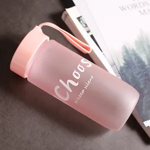 Gros plan d'une bouteille d'eau en plastique rose givré au design minimaliste chic