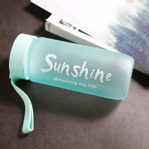 Gros plan d'une bouteille d'eau en plastique vert menthe givré minimaliste.