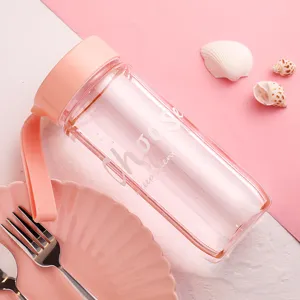 Gros plan d'une bouteille d'eau en plastique rose avec une dragonne en silicone