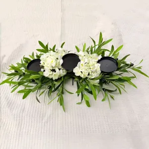 Elegant olive branch centerpiece with white flowers and three black candle holders