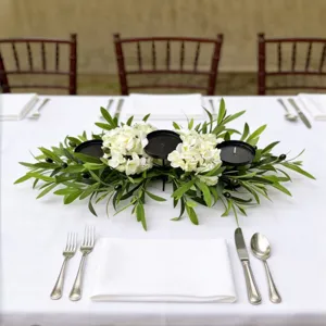 Elegant table setting with olive leaf and white hydrangea floral candle holder centerpiece