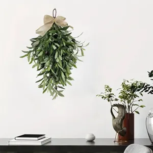 Lifelike artificial olive leaf teardrop swag with rustic burlap bow hung on a white wall