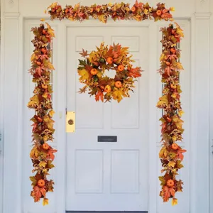 Autumn wreath and garland set with maple leaves and pumpkins on a white front door