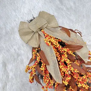 Close-up of autumn berry teardrop wreath with a rustic burlap bow for harvest decor