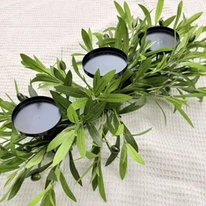 Detailed view of an olive branch candle holder with black iron plates for table decor