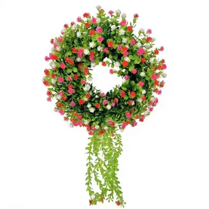 Detailed view of eucalyptus wreath with colorful flowers and hanging green vines.