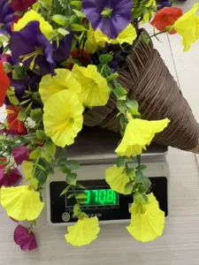 Detail view showing the weight of an artificial morning glory flower basket on a scale