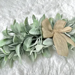 Close-up detail of faux lamb's ear leaf garland with a rustic burlap bow decoration