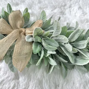 Close-up detail of a soft artificial lamb's ear leaf wreath with a rustic burlap bow