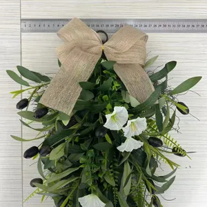 Detailed view of artificial olive teardrop wreath with a burlap bow and scale ruler.