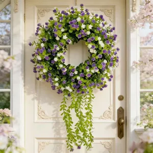 Close-up of artificial eucalyptus wreath with purple and white flowers hanging on a door