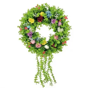 Detailed view of colorful artificial rose wreath with hanging eucalyptus vines.