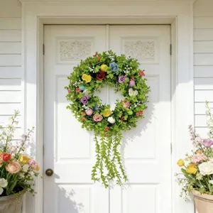 Eucalyptus artificial floral wreath with colorful eggs hanging on a white front door.
