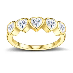 Détail d'une bague en argent S925 plaqué or avec cinq pierres blanches en cœur.