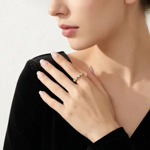 Gros plan d'une élégante bague en or en forme de cœur avec des pierres sur le doigt d'une femme