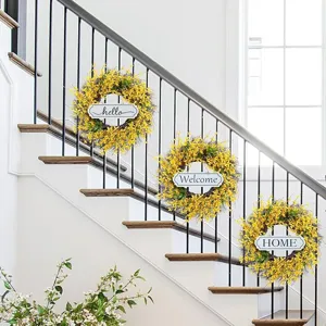 Three yellow forsythia wreaths with welcome signs hanging on indoor staircase railings