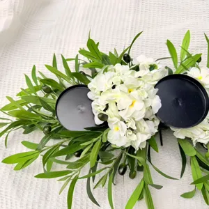 Detail of olive leaf and white hydrangea candle holder on a white textured fabric
