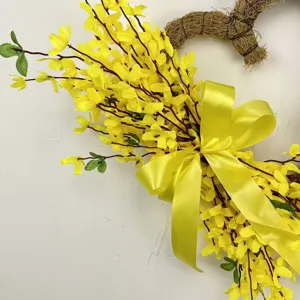 Detail view of a vibrant yellow forsythia heart-shaped wreath with ribbon decoration