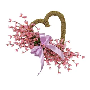 Close-up of pink artificial heart-shaped wreath with lavender bow for home decor