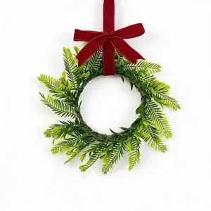 Detailed view of a handmade artificial Persian leaf wreath featuring a vibrant red velvet bow