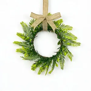 Detail view of an artificial Persian fern leaf wreath with a rustic burlap bow decoration.