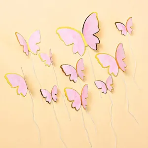 Close-up detail of pink watercolor butterfly cake toppers with elegant gold foil edges