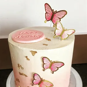 Detailansicht der rosa goldfolierten Schmetterlings-Tortenaufsätze auf Torte