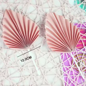 Pink folding fan cake toppers, pleated paper dessert table inserts for party decorations.