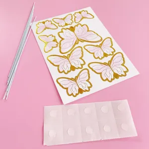Detailansicht des rosa Schmetterling Kuchenstecker Sets mit Goldfolie und Stäbchen