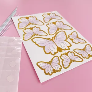 Detailansicht des Schmetterlings-Kuchenaufsatz-Sets mit Goldprägung auf Rosa