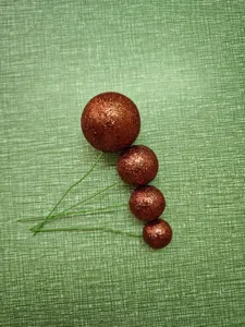 Detalle de cerca de bolas de espuma con purpurina de cobre para decoración de pasteles.