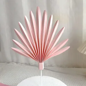 Pink fan-shaped paper cake topper leaves baking decoration for birthday party celebration.