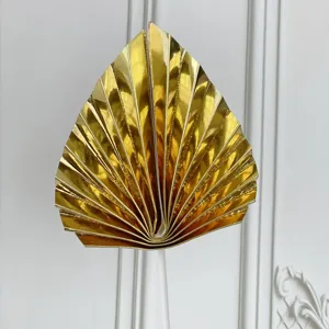 Gold fan cake topper detail view, metallic paper leaf baking decoration for birthday party.