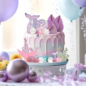 Mermaid cake topper detail showing pastel tails shells and starfish for party decoration.