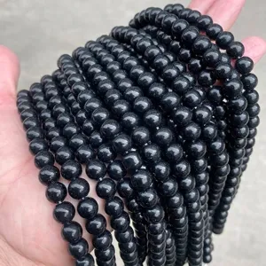 Close-up view of strands of glossy black glass round beads for jewelry DIY projects