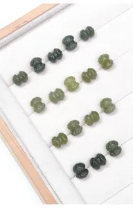Dettaglio che mostra perline di loto in giada verde naturale intagliate in un vassoio