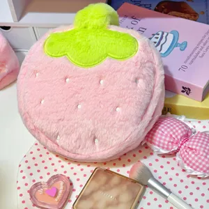 Close-up of strawberry plush cosmetic bag with cute makeup props
