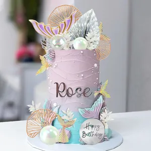 Mermaid birthday cake topper set with pearl balls and custom name decorations for party.