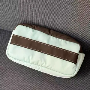 Vista detallada del estuche elegante con costuras cuidadas y un diseño a rayas.