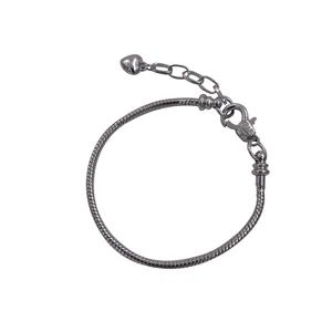 Detail shot of a minimalist silver snake chain bracelet with heart charm and clasp.