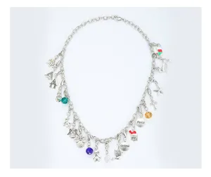 Detailed shot of a silver festive charm necklace featuring snowflake, angel, and Christmas tags