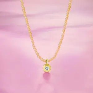 Elegante S925 Silberperlenkette mit rundem Moissanit-Anhänger auf rosa Hintergrund