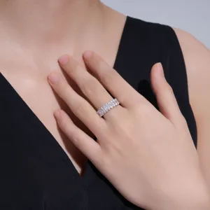 Primer plano de anillo de plata S925 con moissanita talla esmeralda en mano