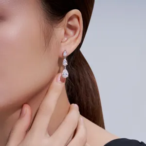 Dettaglio ravvicinato di eleganti orecchini a tre gocce in argento S925 su modella.