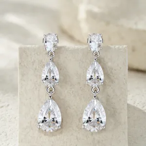 Dettaglio di splendenti orecchini in argento S925 con tripla moissanite a taglio pera