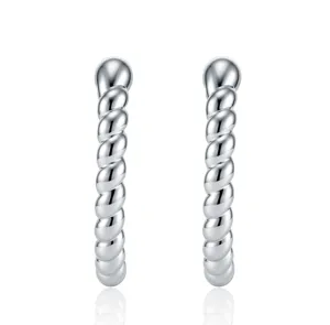 Detailed macro view of elegant silver twist C-shaped ear clips with high polish