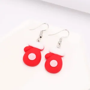 Vue rapprochée de boucles d'oreilles festives en résine en forme de moufles de Noël
